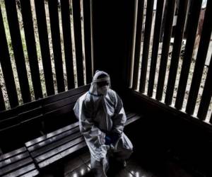 A health worker wearing a protective suit against the spread of the novel coronavirus COVID-19, rests at a health centre in a low-income neighbourhood in San Jose, on July 10, 2020. - Costa Rican authorities announced on Friday the most severe restrictions in recent months to contain a strong outbreak of COVID-19 in the last two weeks. (Photo by Ezequiel BECERRA / AFP)