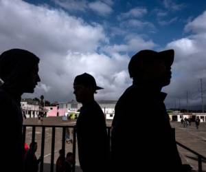 Central American migrants -mostly from Honduras- traveling in a caravan to the United States, are seen after being relocated at a new temporary shelter in east Tijuana, Baja California State, Mexico, in the border with the US on November 30, 2018. (Photo by Guillermo Arias / AFP)