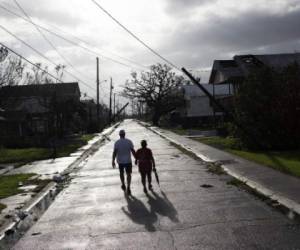 Una pareja camina en Montegut, Louisiana tras el paso del huracán Ida. Al menos dos personas han muerto tras el derrumbe de una de las principales autopistas que unen Luisiana y Misisipi, los dos Estados más golpeados por las tormentas que ha descargado el huracán Ida (Photo by Mark Felix / AFP)