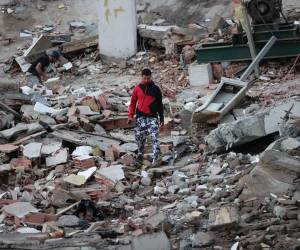 Un residente camina entre los escombros de edificios derrumbados por los terremotos, en la localidad de Catia La Mar, en el estado costero de La Guaira (Venezuela), este jueves La Guaira, un estado costero en el norte del país y vecino a Caracas, es el estado más afectado por los terremotos. EFE/ Ronald Pena R.