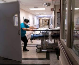 Adrián Parrilla transporta a un paciente a la unidad COVID-19 en California el 19 de febrero de 2021. Los casos del virus en California han bajado tras los récords de infección que reportó enero. (AP Photo/Jae C. Hong)