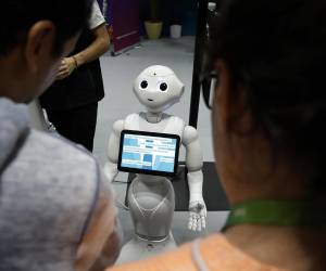 <i>Unos visitantes hablan con el robot 'Pepper' en una imagen de archivo de una feria. EFE/EPA/SEBASTIEN NOGIER</i>