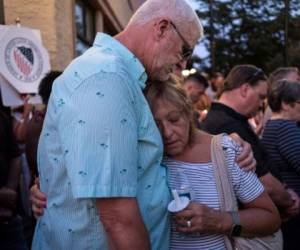 Personas se abrazan tras encender una fela en la vigilia para recordas a las víctimas del tiroteo en Dayton, Ohio el 4 de agosto de 2019. (Photo by Megan JELINGER / AFP)