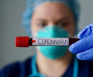 Nurse wearing respirator mask holding a positive blood test result for the new rapidly spreading Coronavirus, originating in Wuhan, China