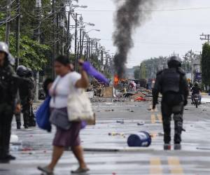<i>Civiles y policías fueron captados este domingo, 22 de junio, en una calle bloqueada durante una nueva jornada de protestas, en Changuinola (Bocas del Toro, Panamá). EFE/Bienvenido Velasco</i>