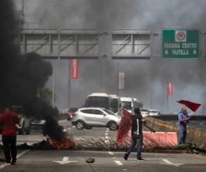 Trabajadores sindicalizados bloquean una carretera en la Ciudad de Panamá, el 18 de julio de 2022. - El gobierno de Panamá y los líderes indígenas llegaron a un segundo acuerdo el domingo para desalojar a todos los manifestantes restantes de la Carretera Panamericana a cambio de precios más bajos del combustible, poniendo fin a un bloqueo de dos semanas que había entregas de alimentos bloqueadas. (Foto de ROGELIO FIGUEROA / AFP)