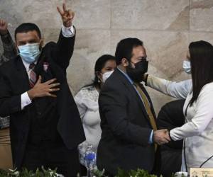 Luis Redondo (2-R), elected-President of the Congress of the Republic's Board of Directors, is greeted by deputies of the Libertad y Refundacion (LIBRE) party, at the installation of the first Legislature 2022-2026, in Tegucigalpa, on January 25, 2022. (Photo by Orlando SIERRA / AFP)