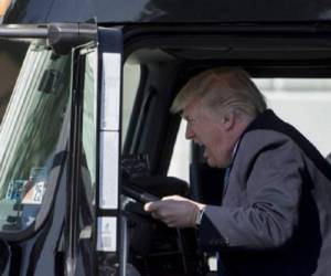 US President Donald Trump sits in the drivers seat of a semi-truck as he welcomes truckers and CEOs to the White House in Washington, DC, March 23, 2017, to discuss healthcare. / AFP PHOTO / JIM WATSON