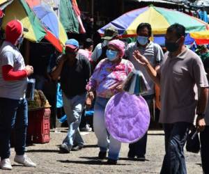 People wear facemasks at a market in Tegucigalpa on June 19, 2020 during the COVID-19 coronavirus pandemic. - The Honduran National System of Risk Management (SINAGER) announced the temporary closure of at least six popular markets as of this Friday to 'readjust' biosecurity measures to prevent further contagion. Honduras has recorded 343 deaths and 10,739 confirmed cases of the new coronavirus. (Photo by ORLANDO SIERRA / AFP)