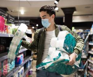 Young Man shopping in a supermarket, breathing through a medical mask because of the danger of getting the flu virus, influenza infection. Corona virus pandemic concept. Covid-19 virus!