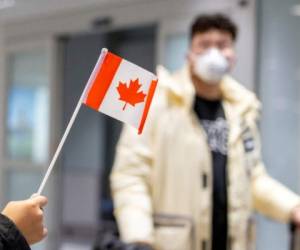FILE PHOTO: A traveller wears a mask at Pearson airport arrivals, shortly after Toronto Public Health received notification of Canada's first presumptive confirmed case of novel coronavirus, in Toronto, Ontario, Canada January 26, 2020. REUTERS/Carlos Osorio/File Photo