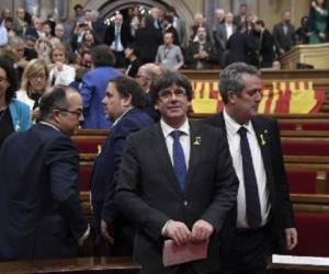 Cerca de 1.700 empresas, entre ellas los dos principales bancos de la región, CaixaBank y Sabadell, han decidido trasladar su sede social fuera de la región, en apenas dos semana. El presidente de Cataluña, Carles Puigdemont, sonríe tras la votación. (Foto: AFP).