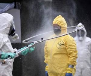 Brazil's military, firefighters and Civil Defense members disinfect each other after cleaning a bus station in Belo Horizonte, Brazil, on April 9, 2020, during the final stage of a course that prepared military personnel from all over the state to fight the spread of the novel coronavirus (COVID-19). (Photo by DOUGLAS MAGNO / AFP)