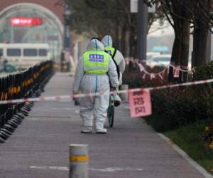 This photo taken on December 22, 2021 shows security guards walking in an area that is under restrictions following a recent coronavirus outbreak in Xi'an in China's northern Shaanxi province. (Photo by AFP) / China OUT