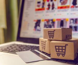 Shopping online concept - Shopping service on The online web. with payment by credit card and offers home delivery. parcel or Paper cartons with a shopping cart logo on a laptop keyboard