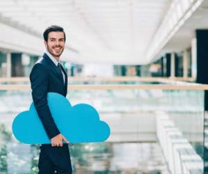 Cheerhul businessman holding a big blue cloud walking in a modern office building, with copy space