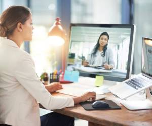 Shot of two colleagues video chatting with each other on a computer at work