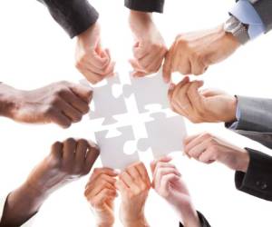 Close-up Photo Of Businesspeople Holding Jigsaw Puzzle