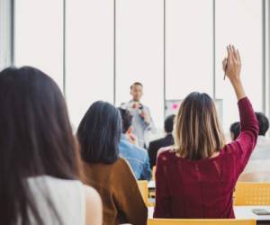 Back view business woman raising hand for asking speaker for question and answer concept in meeting room for seminar