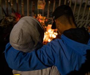 <i>Una pareja presenta sus respetos durante una vigilia frente a las instalaciones de inmigración mexicanas donde al menos 38 migrantes murieron en un incendio, en Ciudad Juárez, estado de Chihuahua, el 28 de marzo de 2023, México. (Foto de Guillermo Arias / AFP)</i>