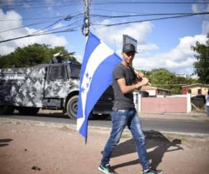 Un simpatizante del candidato opositor, Salvador Nasralla, participa en las marchas en Tegucigalpa, a pesar del Estado de Sitio por 10 días impuesto por el Gobierno. AFP PHOTO / JOHAN ORDONEZ