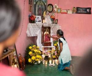 Un familiar de Misael Olivares, de 16 años, reportado como uno de los 53 migrantes que murieron dentro de un tráiler en San Antonio, Texas, reza ante un altar en su casa en San Marcos Atexquilapan, estado de Veracruz, México, 1 de julio de 2022. (Foto por Héctor QUINTANAR / AFP)