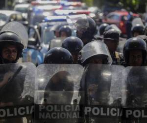 Riot police stand by outstide a parking lot where opposition protesters demonstrating against the government took refuge as police warned they will arrest anyone who 'alters peace and coexistence', in Managua on April 17, 2019. - Nicaragua's opposition said at least 25 people were arrested after defying a protest ban and a heavy riot police presence on the streets of Managua to mark the first anniversary of a deadly uprising against President Daniel Ortega. (Photo by INTI OCON / AFP)