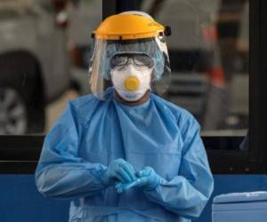 Un trabajador de salud muestra su máscara a la entrada de un punto para realizar pruebas de COVID-19 en Ciudad de Panamá. (Foto Luis ACOSTA / AFP)