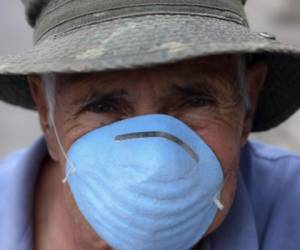 Tomas Aguilar, 78 años, mueve una bandera rojo y blanco como señal que necesita comida (blanco) y medicinas (rojo) en Villa Nueva, Guatemala (Foto Johan ORDONEZ / AFP)