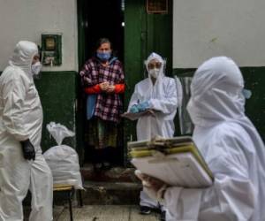 Workers of Bogota's Mayor's office wear protective suits to avoid getting infected with COVID-19 as they conduct a census at Egipto (Egypt) neighbourhood in Bogota on April 19, 2020 to know how many families need to be provided with food to prevent them from go shopping during the new coronavirus pandemic. - The number of coronavirus infections across Latin America surpassed 100,000 on Sunday with nearly 5,000 deaths, according to an AFP tally based on official figures reported by individual countries. (Photo by Diana SANCHEZ / AFP)