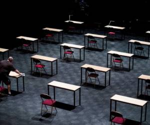 A man disinfects tables in an empty exam room at the 'Ancienne Belgique' (AB) concert hall in Brussels, on June 2, 2020 as Belgium eases lockdown measures taken to curb the spread of the COVID-19 (the novel coronavirus). (Photo by Kenzo TRIBOUILLARD / AFP)