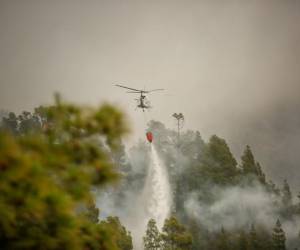 <i>Un helicóptero lanza agua sobre un incendio en el barranco de Jurado sobre el municipio de Tijarafe, en la isla canaria española de La Palma, el 17 de julio de 2023, ya que un incendio forestal que comenzó el 15 de julio ha destruido 4.000 hectáreas de tierra. (Foto de DESIREE MARTIN / AFP)</i>
