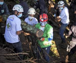 Rescuers of the Green Cross, police and soldiers work to remove rubble while searching for victims of a landslide in Nejapa, El Salvador on October 30, 2020. - A landslide caused by heavy rains left six people dead, 35 disappeared and some 50 homes buried in a rural community of Nejapa, about 15 km north of San Salvador, police reported. (Photo by Yuri CORTEZ / AFP)
