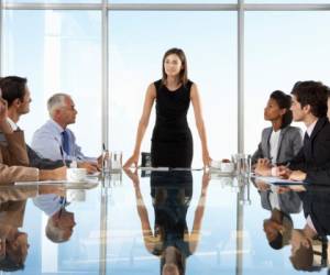 Group Of Business People Having Board Meeting Around Glass Table.