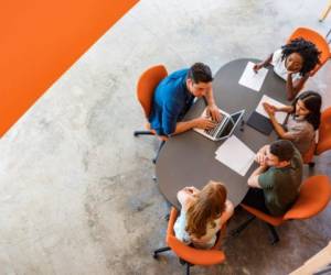 Top down view of a group of young entrepreneurs working together in a start up business meeting