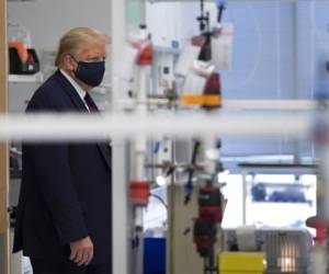 US President Donald Trump wears a mask as he tours a lab where they are making components for a potential vaccine at the Bioprocess Innovation Center at Fujifilm Diosynth Biotechnologies in Morrisville, North Carolina on July 27, 2020. (Photo by JIM WATSON / AFP)