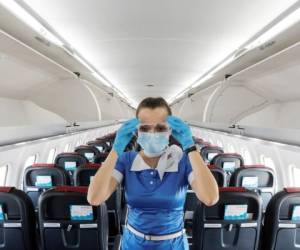 A stewardess of Ukraine's Windrose Airlines adjusts protective glasses prior to the departure for Odesa inside an ATR 72-600 passenger plane operating its first flight at the Boryspil International Airport outside Kyiv, Ukraine June 27, 2020. REUTERS/Valentyn Ogirenko - RC2OHH95QG5E