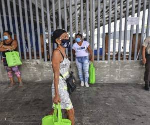 Customers wearing face masks as a preventive measure against the spread of the novel coronavirus (which causes COVID-19) wait in line at a seafood Market in Panama City on April 24, 2020. - According to a projection of the World Food Program, 265 million people could suffer from hunger in 2020, that is to say almost twice more than in 2019, due to the economic impact of this health crisis. (Photo by Luis ACOSTA / AFP)