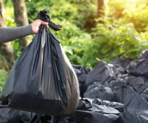 Man Taking Out Garbage In Bags