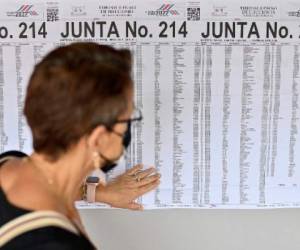 A woman looks at a chart to find the polling station where to vote during general elections in San Jose, on February 6, 2022. - Costa Ricans head to the polls Sunday with a crowded presidential field and no clear favorite for tackling growing economic concerns in one of Latin America's stablest democracies. (Photo by Luis ACOSTA / AFP)