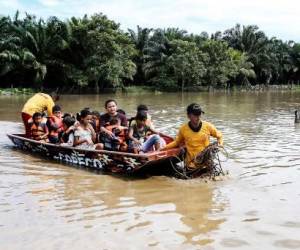 Personas afectadas por inundaciones tras el paso de la Tormenta Tropical Julia, son evacuadas en lancha, en el municipio de Choloma, departamento de Cortés, Honduras, el 10 de octubre de 2022. ( FOTO Wendell ESCOTO / AFP)