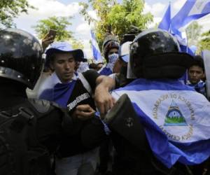 Riot police agents block the road as demonstrators protest during a march to the National Congress to demand justice for the 43 deaths in recent protests in Managua on May 2, 2018Riot police agents blocked a demonstration leaded by students on Wednesday demanding justice for the 43 deaths after days of protests sparked by reforms in the deficit-stricken social security system, but the unrest quickly swelled on the back of widespread resentment of President Daniel Ortega's perceived authoritarianism. / AFP PHOTO / Inti OCON