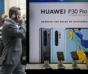A pedestrian walks past a Huawei product stand at an EE telecommunications shop in central London on April 29, 2019. - British Foreign Secretary Jeremy Hunt has urged caution over the role of China's Huawei in the UK, saying the government should think carefully before opening its doors to the technology giant to develop next-generation 5G mobile networks. His comments come after Prime Minister Theresa May conditionally allowed China's Huawei to build the UK 5G network, information that was leaked to a newspaper from top secret discussions between senior ministers and security officials, a leak that has caused a scandal that has rocked Britain's splintered government. (Photo by Tolga Akmen / various sources / AFP)