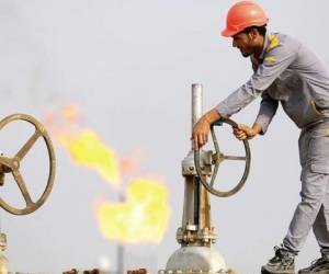 (FILES) In this file photo taken on March 3, 2016, an Iraqi labourer turns a valve at an oil refinery in the newly opened section at the oil refinery of Zubair, southwest of Basra in southern Iraq. - As crude prices plunge, Iraq's oil sector is facing a triple threat that has slashed revenues, risks denting production and may spell trouble for future exports. (Photo by HAIDAR MOHAMMED ALI / AFP)