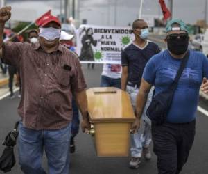 Members of Panama unions protest against the reopening measures adopted by the Panamanian government after the quarantine that was decreed to prevent the spread of the new coronavirus COVID-19 pandemic, in front of the Labor Ministry's headquarters, in Panama City on June 2, 2020. - The government of Panamanian President Laurentino Cortizo, reopened on Monday the construction, non-metallic mining and industry sectors, which were inactive to combat COVID-19, in an attempt to 'avoid the economic collapse' of the country with the highest number of infections in Central America. (Photo by Luis ACOSTA / AFP)