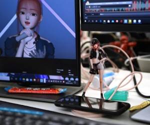 Esta foto tomada el 12 de noviembre de 2020 muestra un recorte de la ídolo virtual Amy en el escritorio de un animador en las oficinas de Beijing Mizhi Tech en Beijing. - Aunque el concepto de ídolo virtual se originó en Japón, estos avatares digitales ahora están robando tiempo aire en China, donde aparecen en programas de televisión, vallas publicitarias e incluso programas de noticias. (Foto de GREG BAKER / AFP) / Para acompañar la historia de AFP China-technology-entertainment, FOCUS de Helen ROXBURGH con Danni ZHU