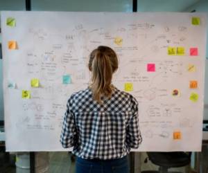 Woman sketching a business plan on a placard at a creative office