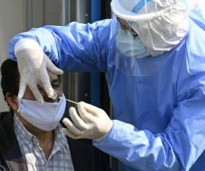 A doctor takes samples for a PCR test to a man whit COVID-19 symptoms at the mobile health unit in Villa Fiorito, Buenos Aires outskirts, Argentina, on August 3, 2020 amid the COVID-19 pandemic. - Villa Fiorito has some 43,000 inhabitants and is hometown of former footballer Diego Maradona. Argentina surpassed 200,000 cases of Covid-19 on the eve, the Ministry of Health reported, and announced the ban on social gatherings throughout the country starting today. (Photo by JUAN MABROMATA / AFP)