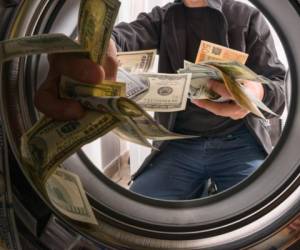 One caucasian male throwing money into a washing machine