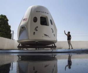 HAWTHORNE, CA - AUGUST 13: A reporter takes a smart phone photo of a mock up of the Crew Dragon spacecraft during a media tour of SpaceX headquarters and rocket factory on August 13, 2018 in Hawthorne, California. SpaceX plans to use the spaceship Crew Dragon, a passenger version of the robotic Dragon cargo ship, to carry NASA astronauts to the International Space Station for the first time since the Space Shuttle program was retired in 2011. David McNew/Getty Images/AFP